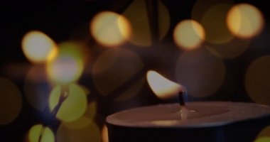 Yanıp sönen peri ışıklarıyla yanan mum animasyonu. Noel kutlaması konsepti dijital olarak oluşturulmuş görüntü.