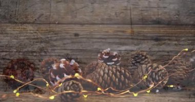 Ahşap yüzey üzerinde çam kozalakları Noel süslemesi. Noel kutlaması konsepti dijital olarak oluşturulmuş görüntü.