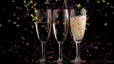 Çok renkli konfetilerin üç şampanya kadehine düşüşünün animasyonu. Yeni yıl kutlamaları konsepti dijital olarak oluşturuldu.