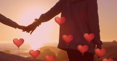 Aşık çiftlerin orta kesiminde yüzen kırmızı kalp balonları deniz kenarında el ele tutuşuyor. Dijital ortamda oluşturulan Sevgililer Günü kutlaması konseptiniz kutlu olsun..