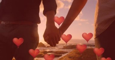 Aşık çiftlerin orta kesiminde yüzen kırmızı kalp balonları deniz kenarında el ele tutuşuyor. Dijital ortamda oluşturulan Sevgililer Günü kutlaması konseptiniz kutlu olsun..