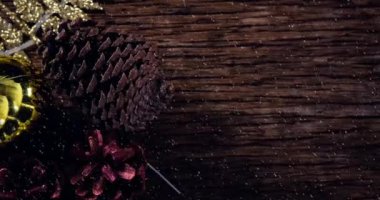 Yılbaşı kozalakları süslenmiş ve tahtaya kar yağmış. Noel kutlaması konsepti dijital olarak oluşturulmuş görüntü.