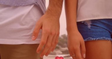 Aşık çiftlerin orta kesiminde yüzen kırmızı kalp balonları deniz kenarında el ele tutuşuyor. Dijital ortamda oluşturulan Sevgililer Günü kutlaması konseptiniz kutlu olsun..