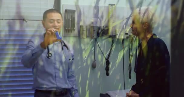 病院の先輩女性患者に吸入器を与える男性医師以上の風の強いフィールド上の草のアニメーション グローバル医療コンセプトデジタル複合体 — ストック動画