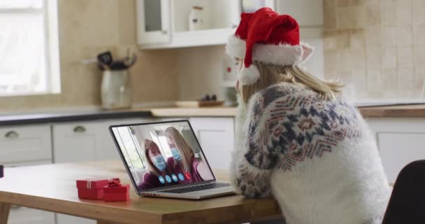 카프카스 여자가 모자를 크리스마스 집에서 비디오 채팅으로 노트북을 사용하는 크리스마스에 — 비디오