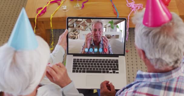 在家里 在笔记本电脑视频聊天的白种人老夫妇戴着派对帽 — 图库视频影像