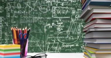 Yeşil arkaplanda yüzen matematiksel denklemlere karşı okul eşyaları ve gözlükler. okul ve eğitim kavramı