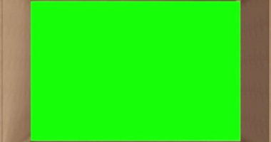 Yeşil ekranın üzerinde kahverengi karton kutunun içinde, kapağı siyah arka planda kapanıyor. Sevkiyat ya da ulaşım hazırlığı için paket kutusu.