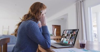 Beyaz bir kadın iş arkadaşlarıyla konuşurken bilgisayar ve kulaklık kullanıyor. Karantina süresince evde tek başına kalmak..