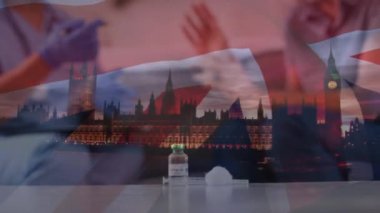 Aşı şişesi ve şırıngayla İngiltere ve Londra manzaralarının animasyonu. Coronavirus covid 19 salgını sırasında sağlık ve koruma dijital olarak üretilen video.