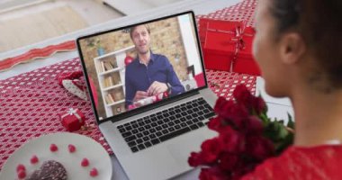 Sevgililer gününde çeşitli çiftler ekranda elinde çiçek tutan kadınlara yüzük gösteren bir video sunucusuyla çıkıyorlar.