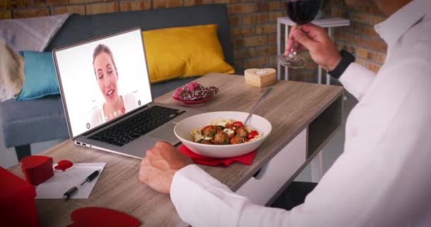 Blank paar op een valentijnsdag video oproep vrouw op laptop scherm zwaaien man eten maaltijd — Stockvideo