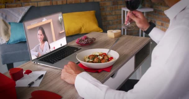 Vielfältiges Paar auf einem Valentinstag Date Video-Anruf Frau auf Laptop-Bildschirm lächelnder Mann beim Essen — Stockvideo