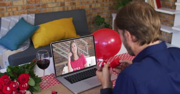 Caucásico pareja en un valentines fecha video llamada hombre mostrando anillo a mujer en pantalla — Vídeos de Stock