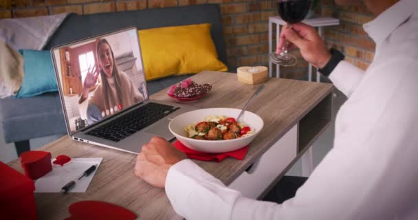 Кавказская пара делает валентинки свидание видео звонок мужчина ест еду женщина смеется на экране ноутбука — стоковое видео
