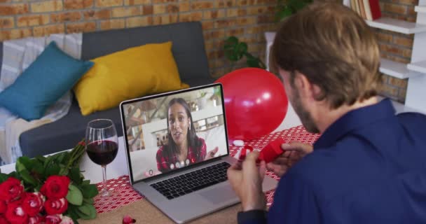 Zróżnicowana para na walentynki randka wideo połączenie mężczyzna pokazując pierścień do kobiety na ekranie laptopa — Wideo stockowe