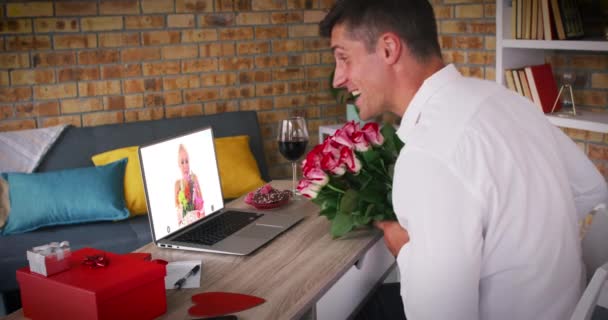 Caucásico pareja sosteniendo flores haciendo valentines fecha vídeo llamada hombre soplando beso a mujer en lapt — Vídeos de Stock
