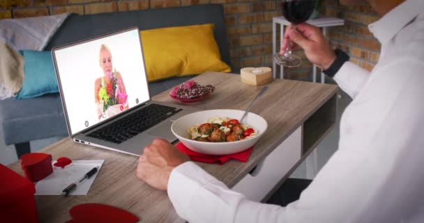 Blank paar op een valentijnsdag video oproep vrouw op laptop scherm met bloemen man eten m — Stockvideo