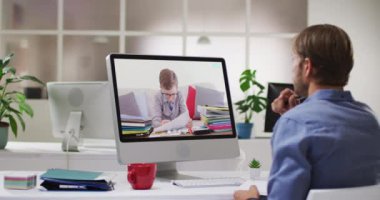 Beyaz erkek öğretmen okul çocuğuyla video görüşmesinde bilgisayar kullanıyor. Çevrimiçi eğitim karantina süresince evde tek başına kalıyor..