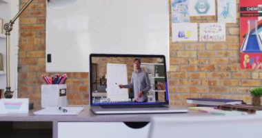 Beyaz erkek öğretmen video görüşmesi sırasında dizüstü bilgisayarda görüntülendi. Çevrimiçi eğitim karantina süresince evde tek başına kalıyor..