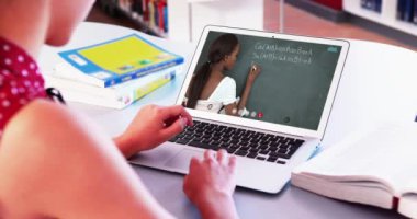 Beyaz kız öğrenci bayan öğretmenle video görüşmesinde dizüstü bilgisayar kullanıyor. Çevrimiçi eğitim karantina süresince evde tek başına kalıyor..