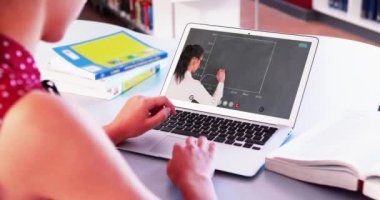 Beyaz kız öğrenci bayan öğretmenle video görüşmesinde dizüstü bilgisayar kullanıyor. Çevrimiçi eğitim karantina süresince evde tek başına kalıyor. Not alıyorum.