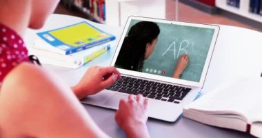 Beyaz kız öğrenci bayan öğretmenle video görüşmesinde dizüstü bilgisayar kullanıyor. Çevrimiçi eğitim karantina süresince evde tek başına kalıyor. Not alıyorum.