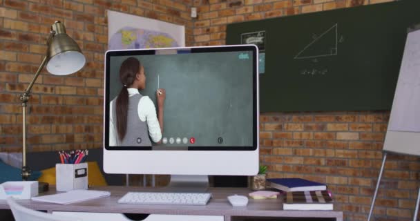 ビデオ通話中にコンピュータ画面に表示される混合レース女性教師 隔離中に自宅に隔離されているオンライン教育 — ストック動画