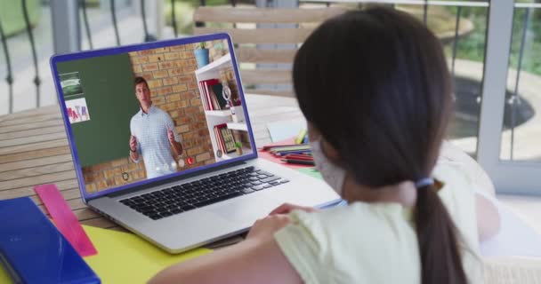 Blank Schoolmeisje Gezichtsmasker Met Laptop Videogesprek Met Mannelijke Leraar Online — Stockvideo