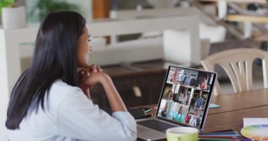 Beyaz kadın bilgisayarını evden iş arkadaşlarıyla görüntülü konuşma için kullanıyor. Karantina süresince evde tek başına kalmak..