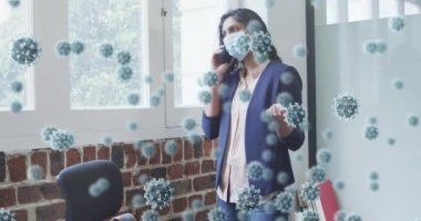 Ofiste akıllı telefon kullanarak yüz maskesi takan kadının üzerinde yüzen kovid 19 hücrenin animasyonu. Coronavirus covid 19 salgını sırasında sağlık ve korunma, dijital olarak üretilen video.