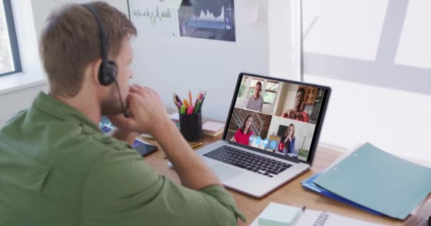 白人男子使用笔记本电脑和电话耳机与同事视频通话 隔离隔离期间在家中自我隔离 — 图库视频影像