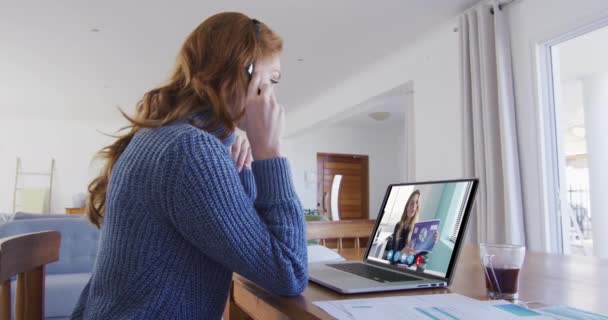 白人妇女使用笔记本电脑和电话耳机与女同事视频通话 隔离隔离期间在家中自我隔离 — 图库视频影像
