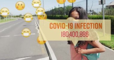 Covid 19 enfeksiyon numarası ve maskeli okul çocuğunun karşıya geçtiği emojilerin animasyonu. Coronavirus covid 19 salgını sırasında sağlık ve korunma, dijital olarak üretilen video.