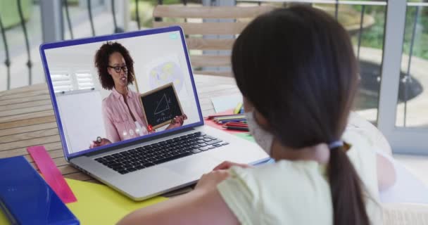白种人女学生戴着面具 与女教师在视频通话中使用笔记本电脑 在隔离隔离期间 在线教育在家中自我隔离 — 图库视频影像
