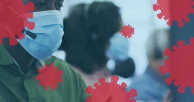 Yüz maskesi takan meslektaşlarıyla birlikte yüzen kovid 19 hücre ikonlarının animasyonu. Coronavirus covid 19 salgını sırasında sağlık ve korunma, dijital olarak üretilen video