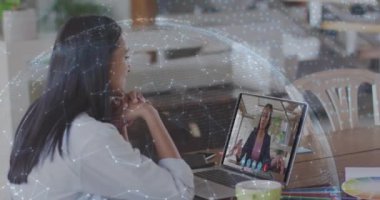 Arka plandaki video konuşmasında dizüstü bilgisayarı kullanan bir kadınla bağlantılı dünya animasyonu. Dijital arayüz küresel bağlantı ve dijital olarak oluşturulan iletişim konsepti.