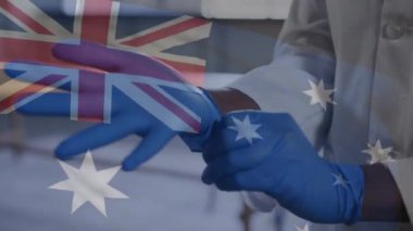 Yeni Zelanda bayrağından feragat etmeye karşı cerrahi eldiven giyen erkek doktorun orta bölümü. Coronavirus covid-19 salgın konsepti.