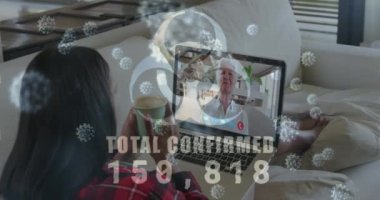 Covid19 hücrelerinin animasyonu ve video aramasında dizüstü bilgisayar kullanan kadınların sayısı. Dijital arayüz küresel covid 19 salgını, bağlantı ve iletişim konsepti dijital olarak oluşturulmuş video.