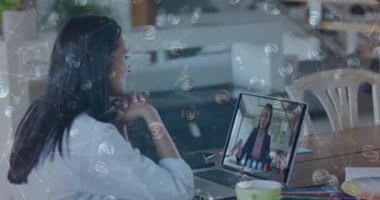 Kadın meslektaşıyla evdeki bilgisayarında görüntülü konuşma yapan kadına karşı yüzen bağlantılar ve bitcoinler ağı. küresel finansman ve ağ kurma kavramı