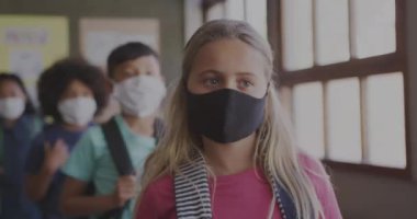 Okul eşyaları simgelerinin okulda maskeli okul çocukları üzerinde canlandırılması. küresel covid 19 salgın, eğitim ve öğrenme konsepti dijital olarak oluşturulmuş video.