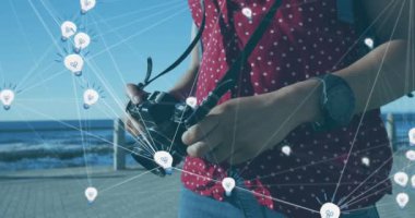 Kamerayı tutan kadının üzerindeki ampul simgeleriyle bağlantı ağının animasyonu. Dijital arayüz küresel ağ bağlantısı ve dijital olarak oluşturulan iletişim konsepti.