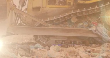 Atık imha alanındaki buldozer üzerinde parlayan ışığın animasyonu. Çevre, küresel ısınma ve iklim değişikliği kavramı dijital olarak oluşturulmuş video.