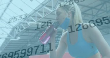 Yüz maskesi takmış kadın üzerinde değişen numaraların canlandırması. Egzersiz yaparken içme suyu molası veriyor. küresel covid 19 salgını, korunma ve zindelik kavramı dijital olarak oluşturuldu.