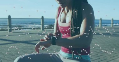 Deniz kenarındaki gezinti güvertesinde akıllı yamaç kullanan kadın hakkındaki istatistik ve grafiklerin animasyonu. dijital arayüz küresel spor ve performans konsepti dijital olarak oluşturulmuş video.