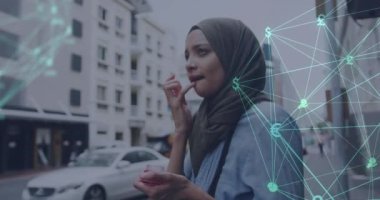 Şehir caddesinde tesettürlü kadın ve iş ikonlarından oluşan bir ağın animasyonu. küresel iletişim teknolojisi dijital arayüz kavramı, dijital olarak oluşturulmuş video.