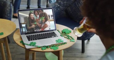 Laptop 'ta bira içen adam arkadaşlarıyla Aziz Patrick gününü kutluyor. İrlanda geleneği şenlik ve kutlama.