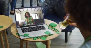 Laptop 'ta bira içen adam arkadaşlarıyla Aziz Patrick gününü kutluyor. İrlanda geleneği şenlik ve kutlama.