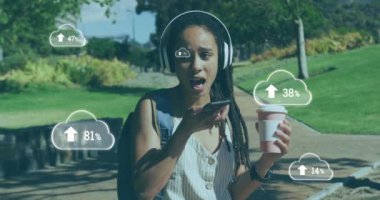 Parkta akıllı telefondan konuşan kadının üzerinde oklar olan bulutların animasyonu. dijital arayüz küresel spor ve performans konsepti dijital olarak oluşturulmuş video.