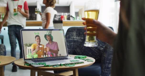 ラップトップビデオでビールを飲んでいる女性は友人とパトリックの日を祝う アイルランドの伝統祭りやお祝い — ストック動画
